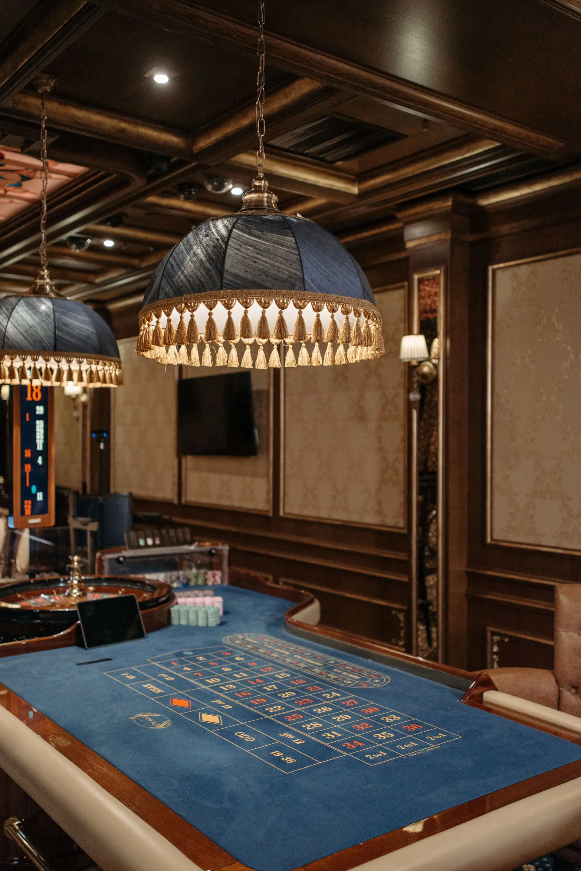 Interior de casino con mesas y lámparas suspendidas